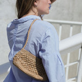 petit sac baguette en raphia thé porté à l'épaule 
