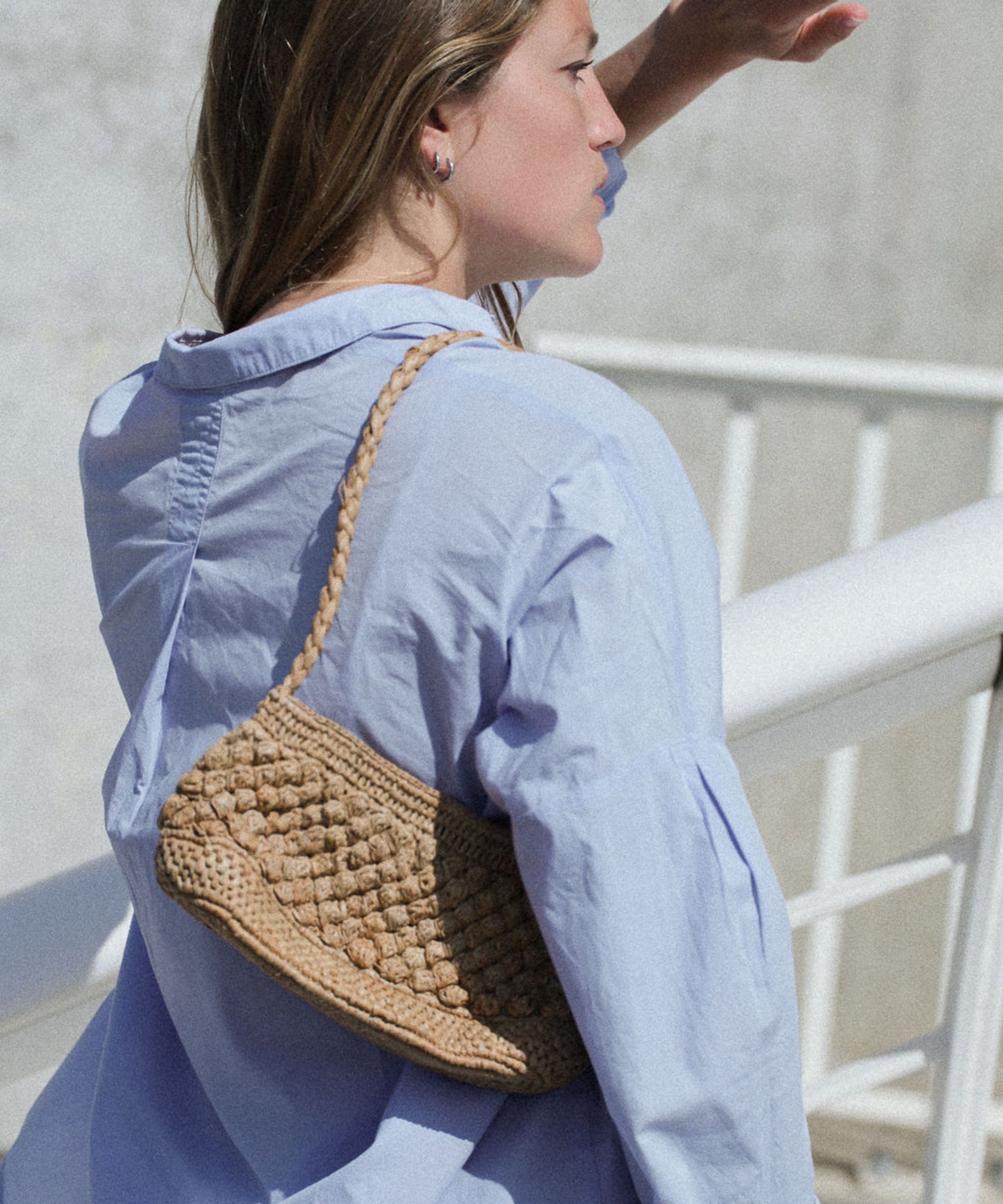 petit sac baguette en raphia thé porté à l'épaule 