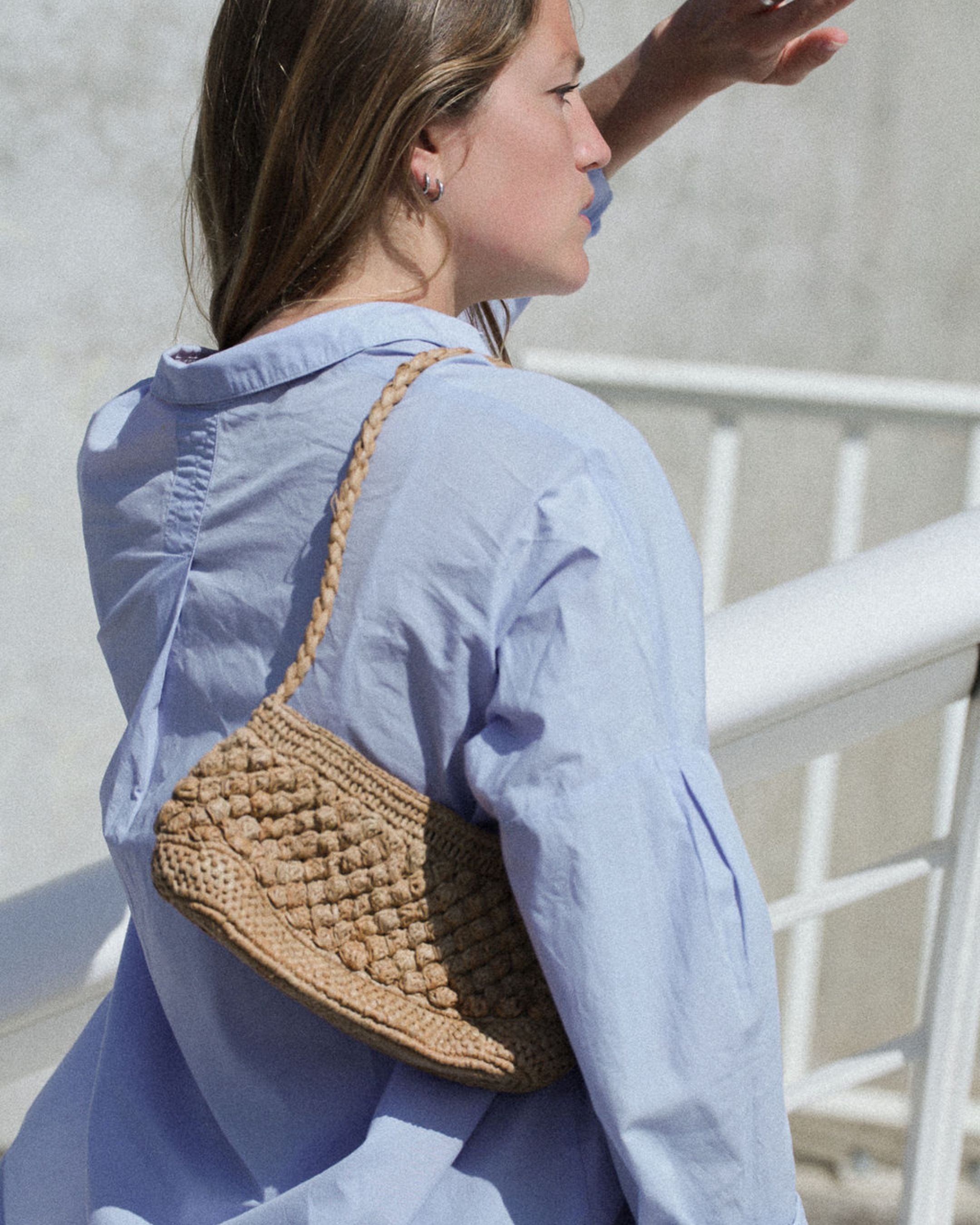 petit sac baguette en raphia thé porté à l'épaule 