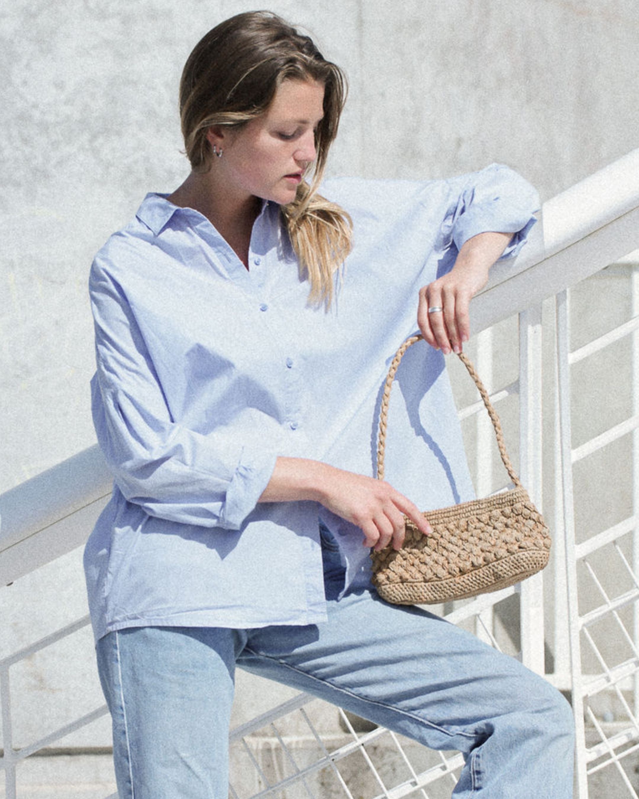 sac baguette marron clair  en raphia boules porté avec une tenue décontractée