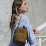 petit sac seau en crochet de raphia vert automne porté à l'épaule