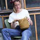 petit sac seau en raphia vert automne porté avec une tenue de ville