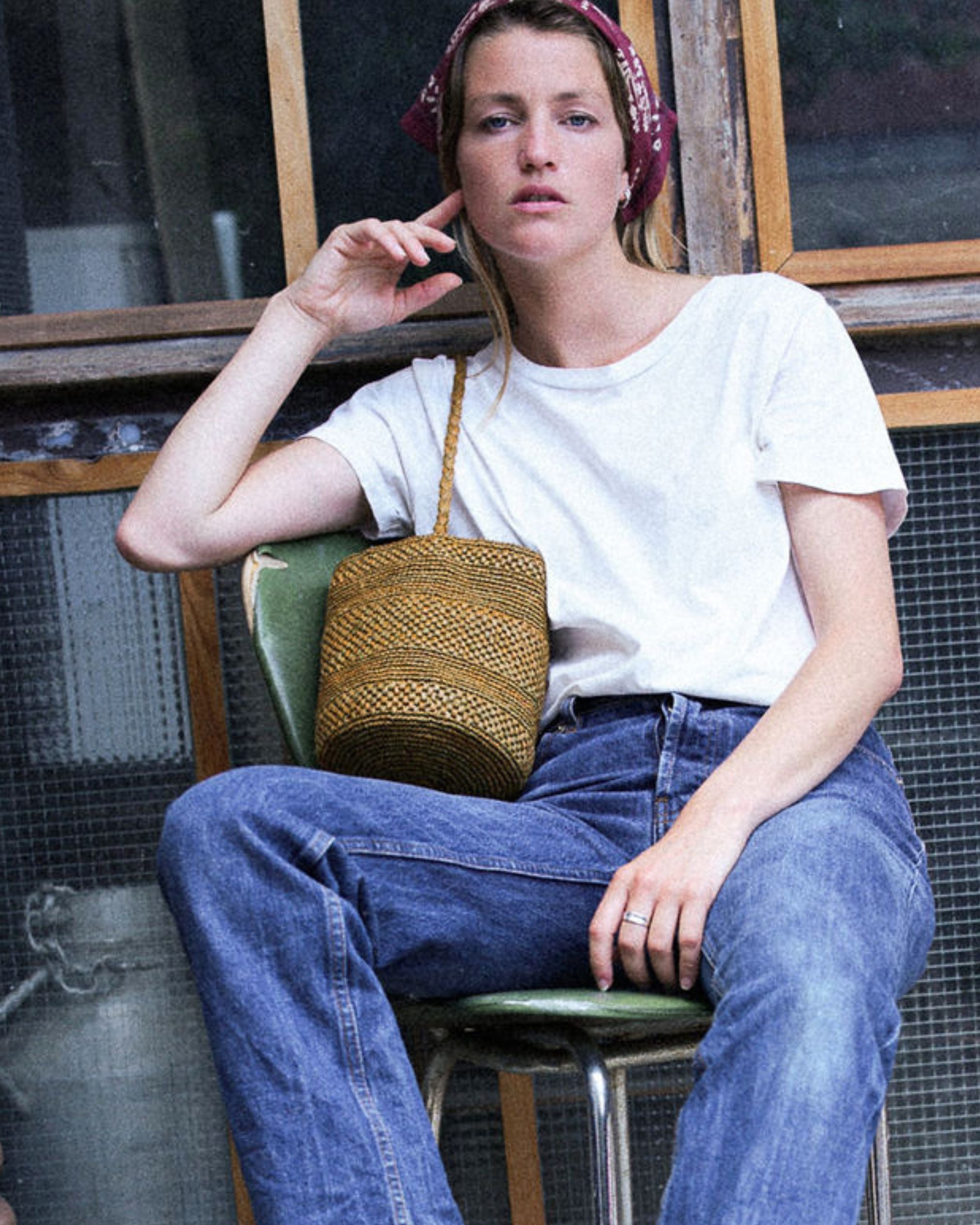 petit sac seau en raphia kaki porté avec un jean 