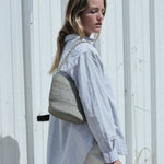 petit sac seau en raphia bleu gris porté à l'épaule
