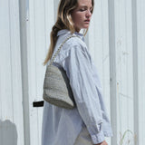 petit sac seau en raphia bleu gris porté à l'épaule