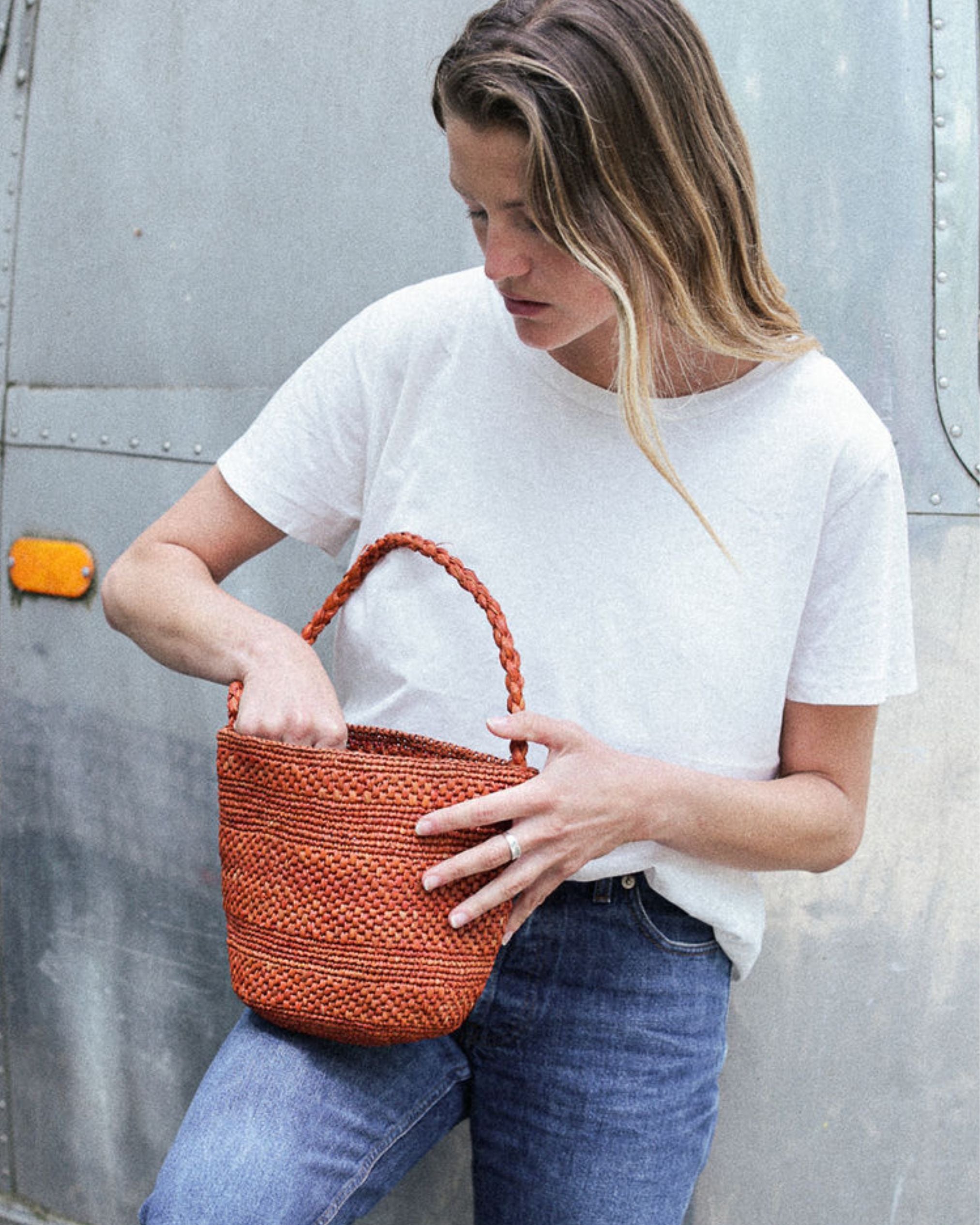petit sac seau en raphia terracotta porté avec une tenue de ville