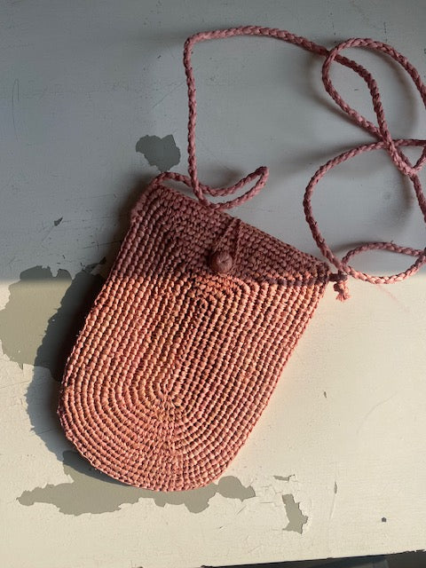 zoom sur la pochette à bandoulière ajustable pour téléphone en raphia rose blush
