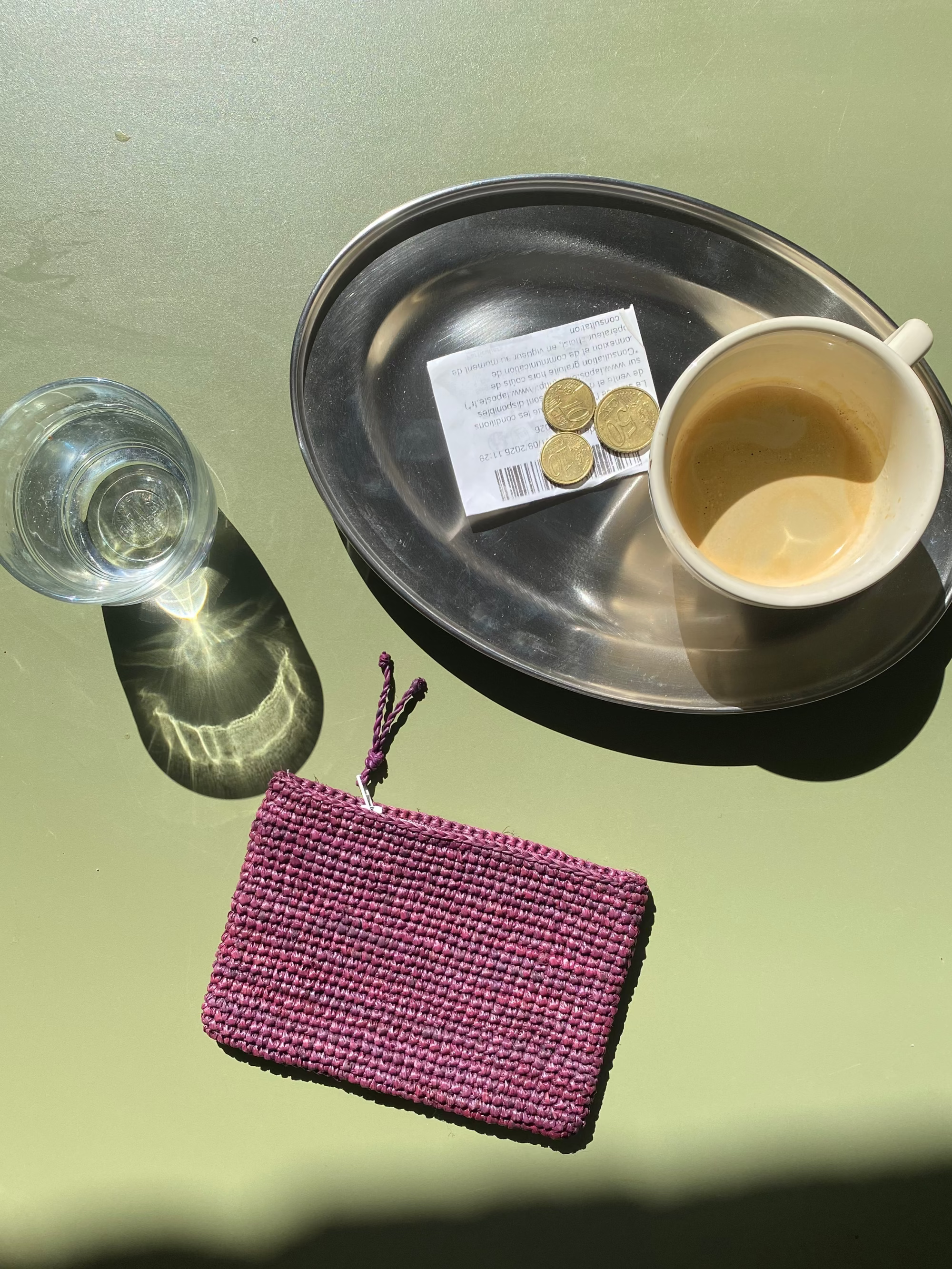 mise en scène du porte carte en raphia bordeaux à la terrasse d'un café
