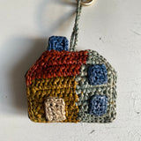 zoom sur le petit porte clés/gri-gri en raphia fait main en forme de maison