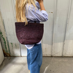 sac cabas ajouré en raphia chocolat porté à l'épaule avec une tenue décontractée