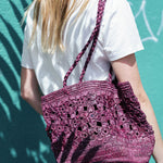 sac seau en crochet fleurs bordeaux porté à l'épaule