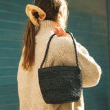Sac seau en raphia noir porté à l’épaule – SINY