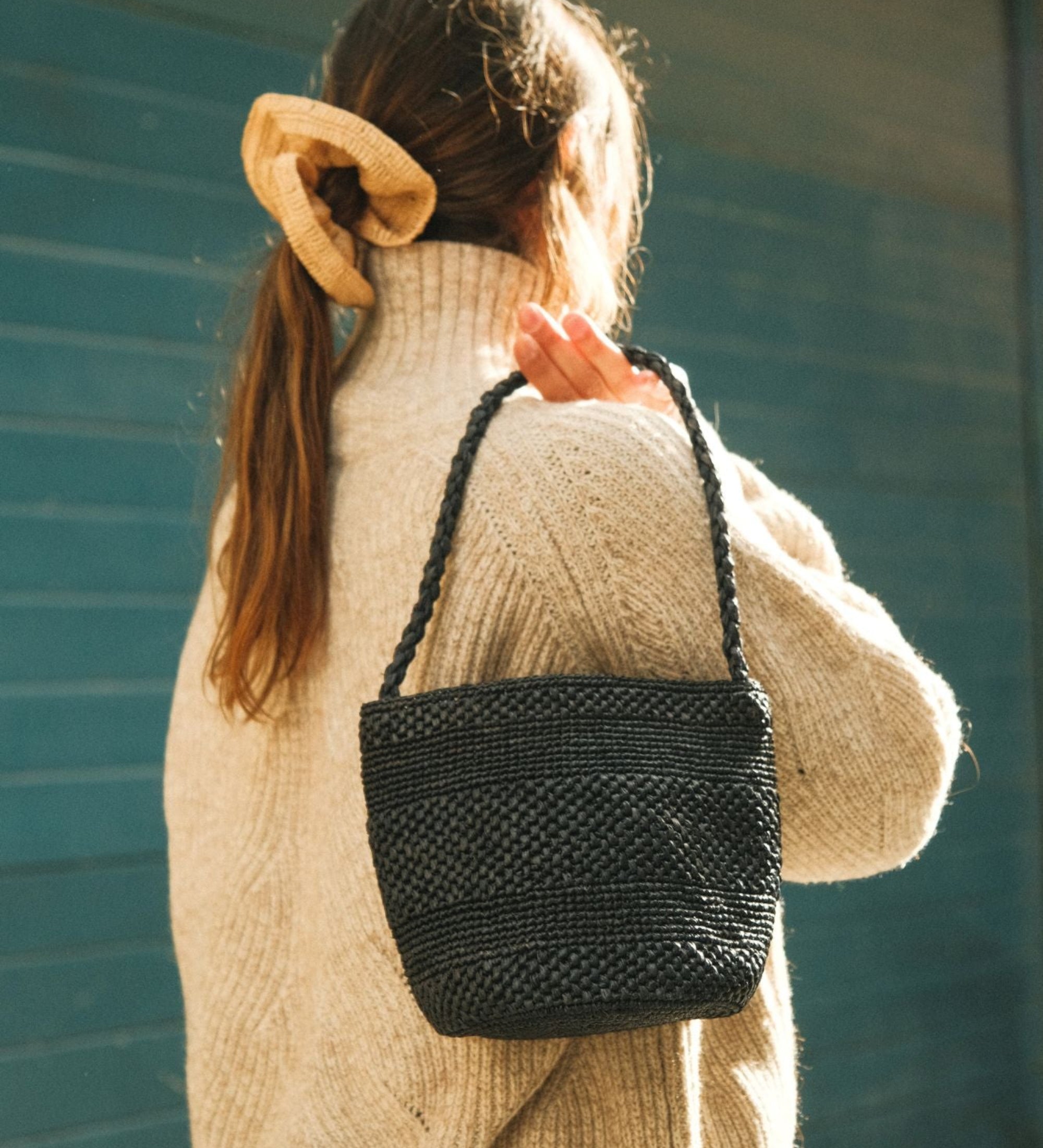 Sac seau en raphia noir porté à l’épaule – SINY