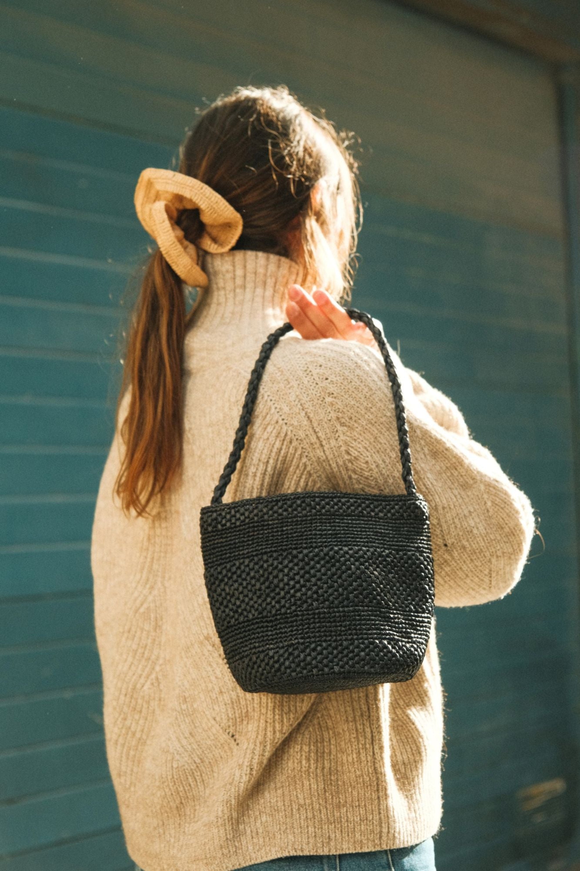 Sac seau en raphia noir porté à l’épaule – SINY