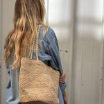 sac seau en raphia naturel porté avec un look de rentrée 