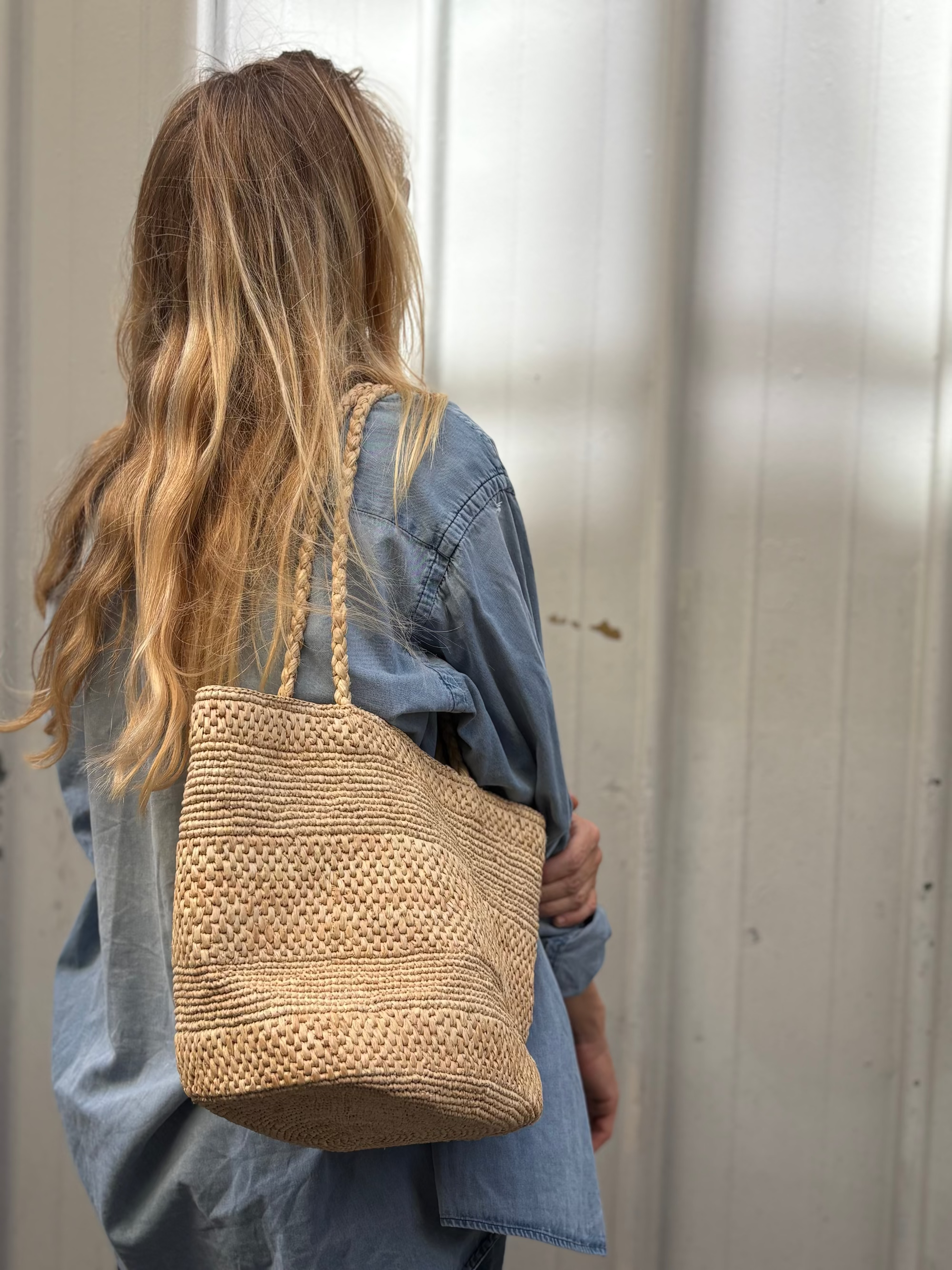 sac seau en raphia naturel porté avec un look de rentrée 