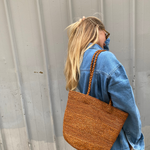 sac seau en raphia cannelle porté à l'épaule 