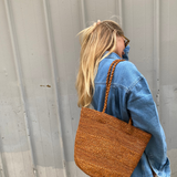 sac seau en raphia cannelle porté à l'épaule 