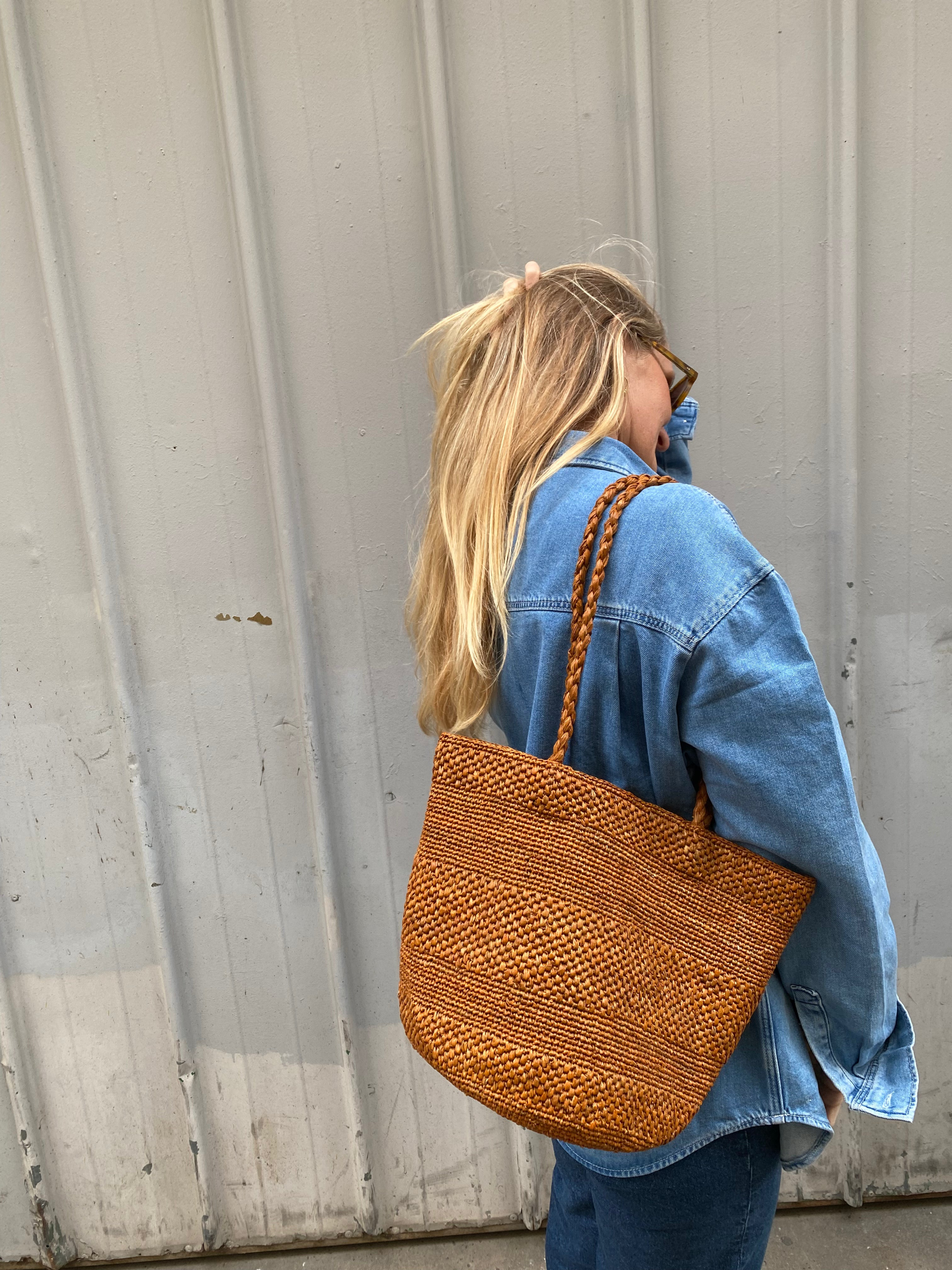 sac seau en raphia cannelle porté à l'épaule 