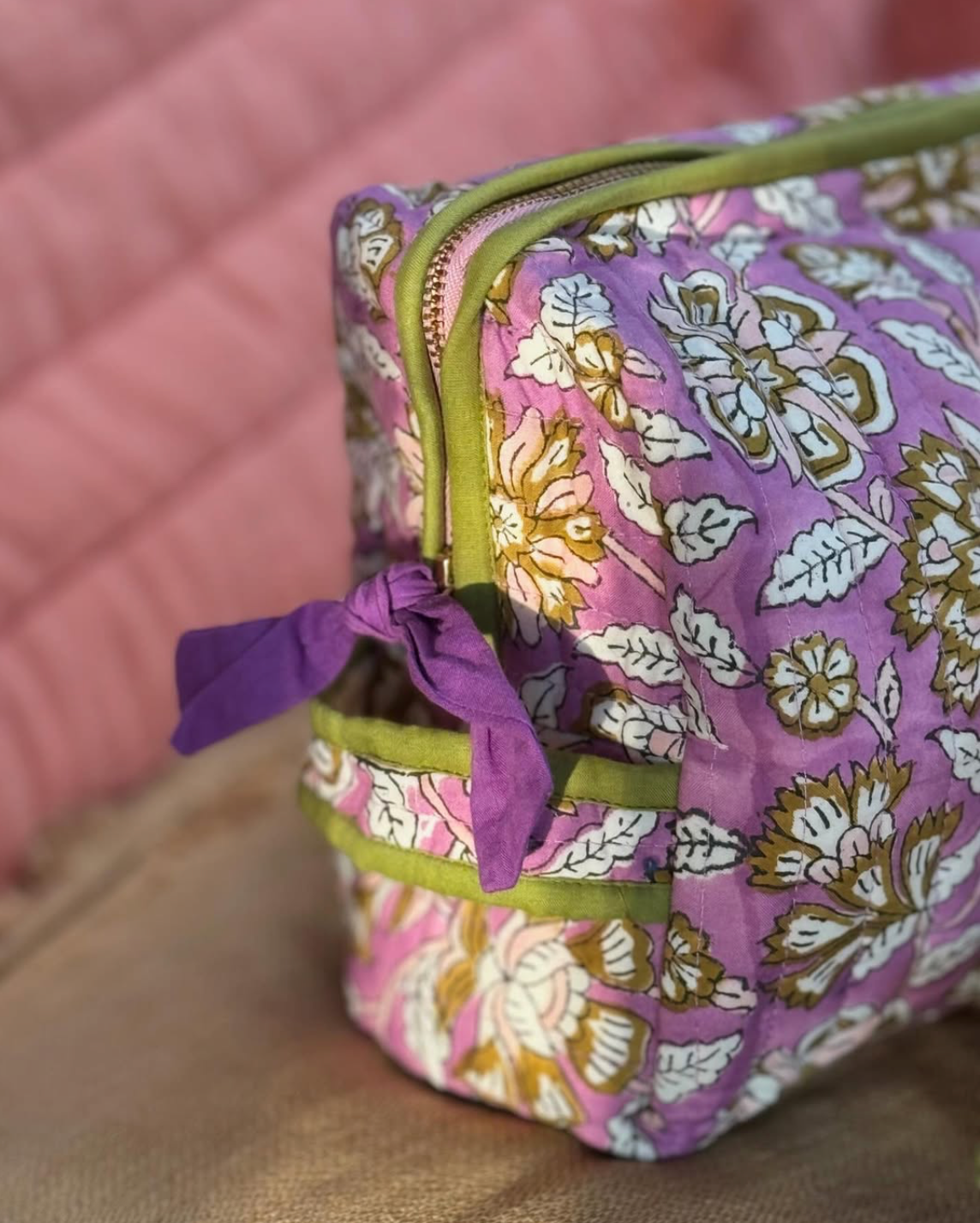 zoom sur la poignée et la fermeture de la trousse de toilette carthage en coton matelassé imprimé lilas