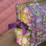 zoom sur la poignée et la fermeture de la trousse de toilette carthage en coton matelassé imprimé lilas