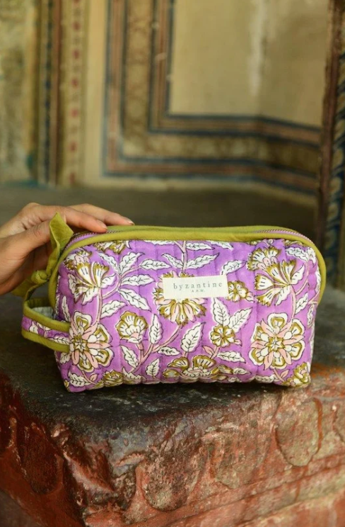 trousse de toilette en coton matelassé imprimé de motifs floraux sur fond lilas, avec bordure kaki en contraste