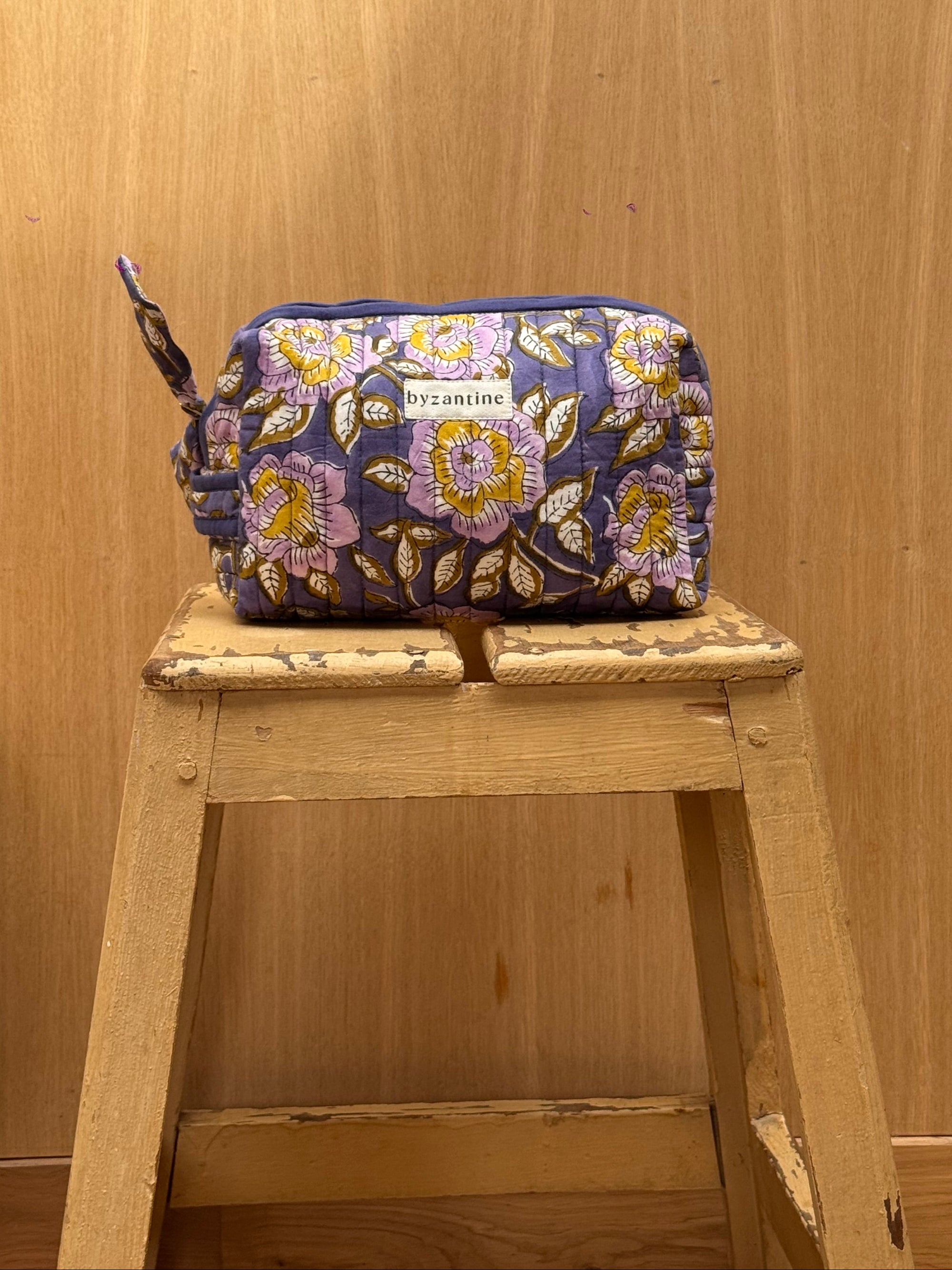 trousse de toilette en coton matelassé imprimé d'un motif floral sur fond marine