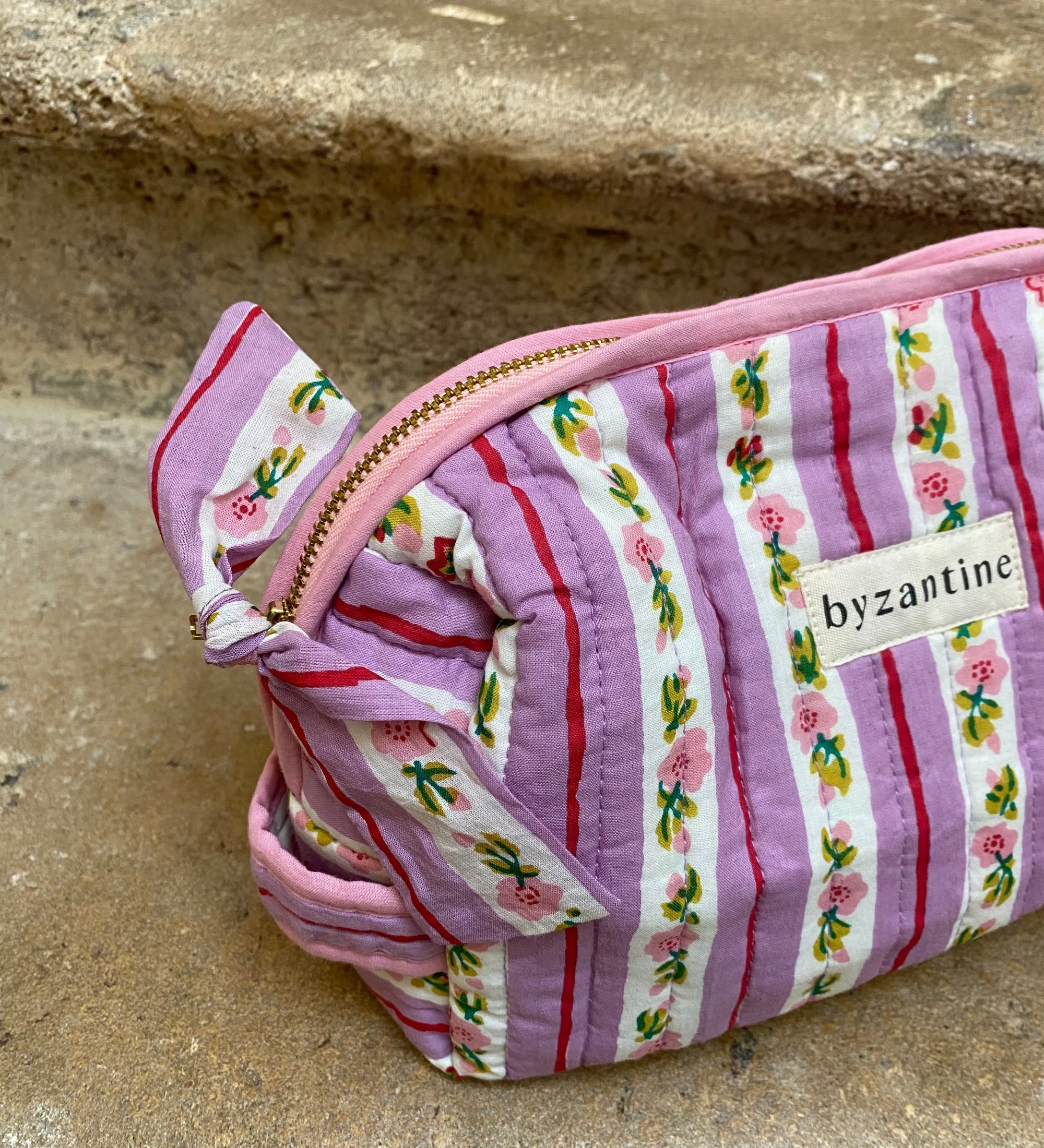 zoom sur la poignée et la fermeture de la petite trousse en coton rayé lilas