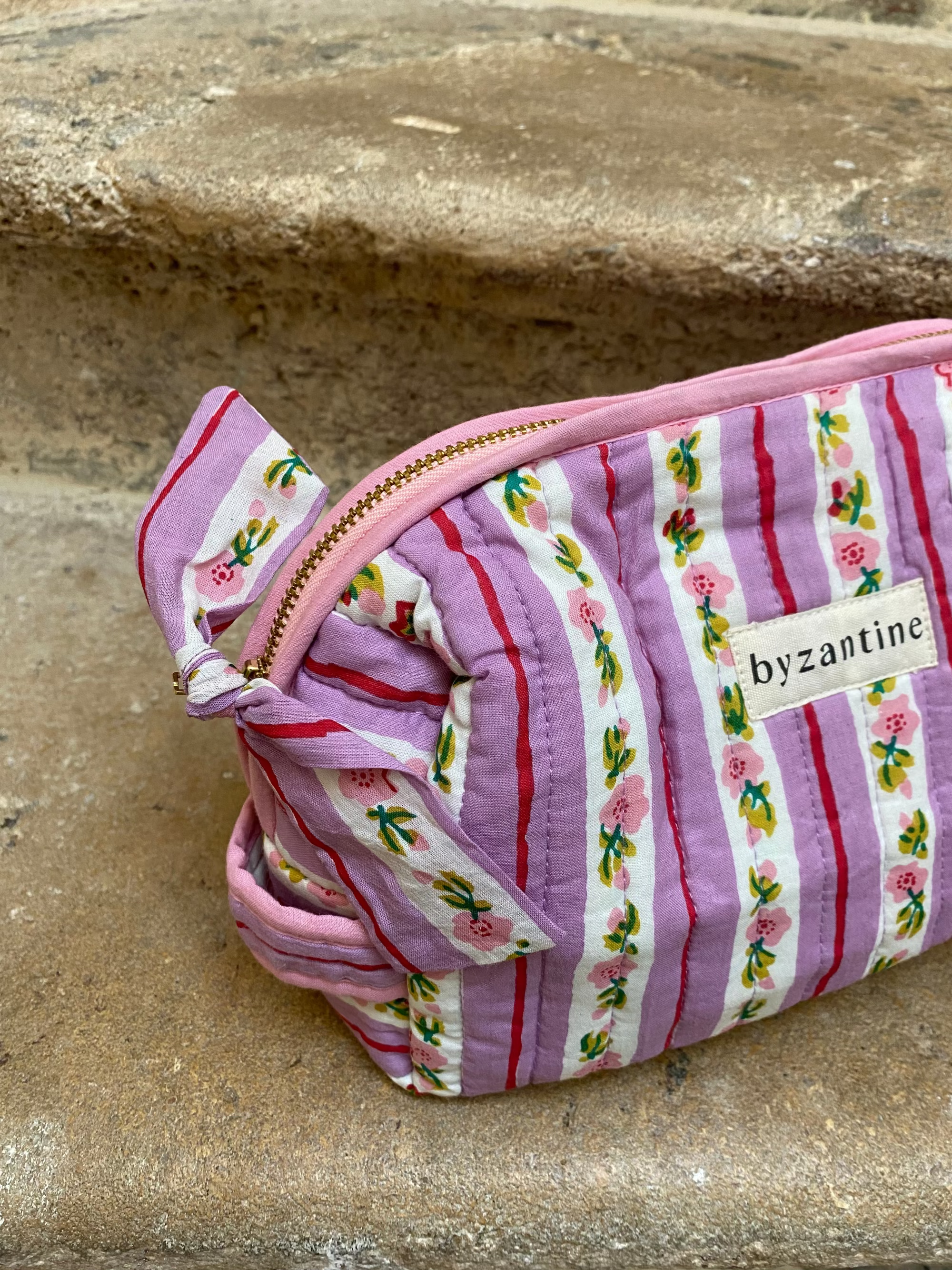 zoom sur la poignée et la fermeture de la petite trousse en coton rayé lilas