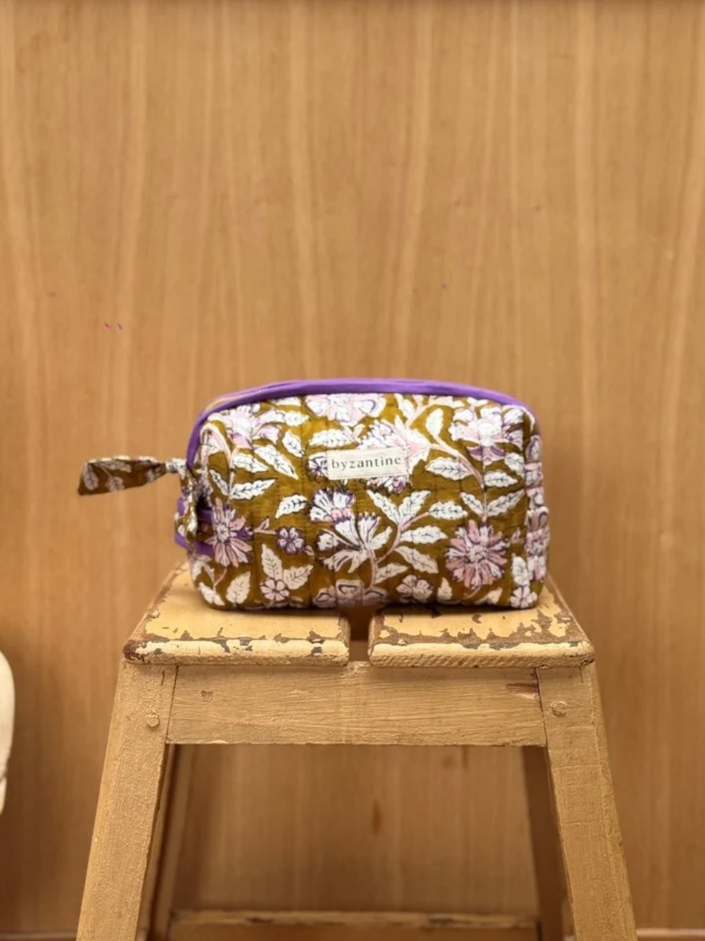 trousse de toilette en coton matelassé imprimé d'un joli motif floral sur un fond kaki- bordure violette en contraste 