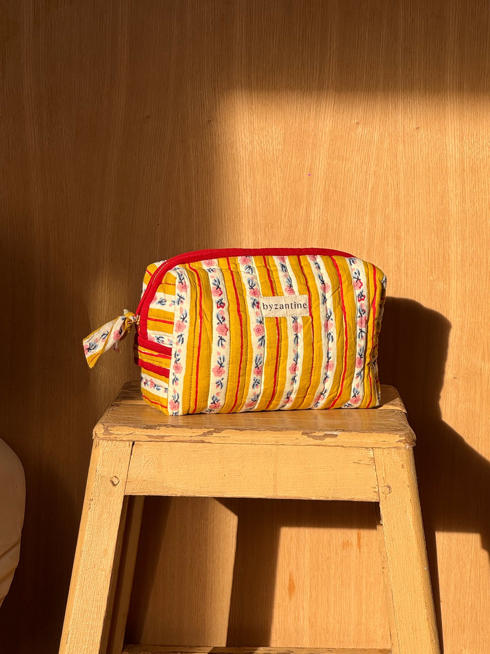 trousse de toilettes en coton matelassé imprimé aux motifs floraux rose pâle et rayures jaunes passion- fermeture en contraste rouge