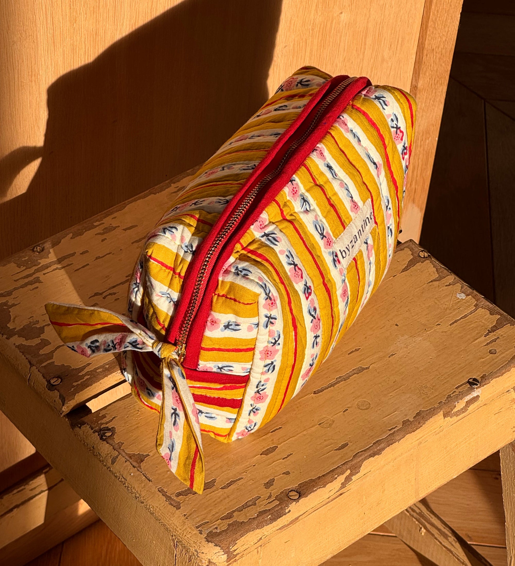 vue de haut de la trousse de toilette en coton matelassé imprimé FLORA jaune passion
