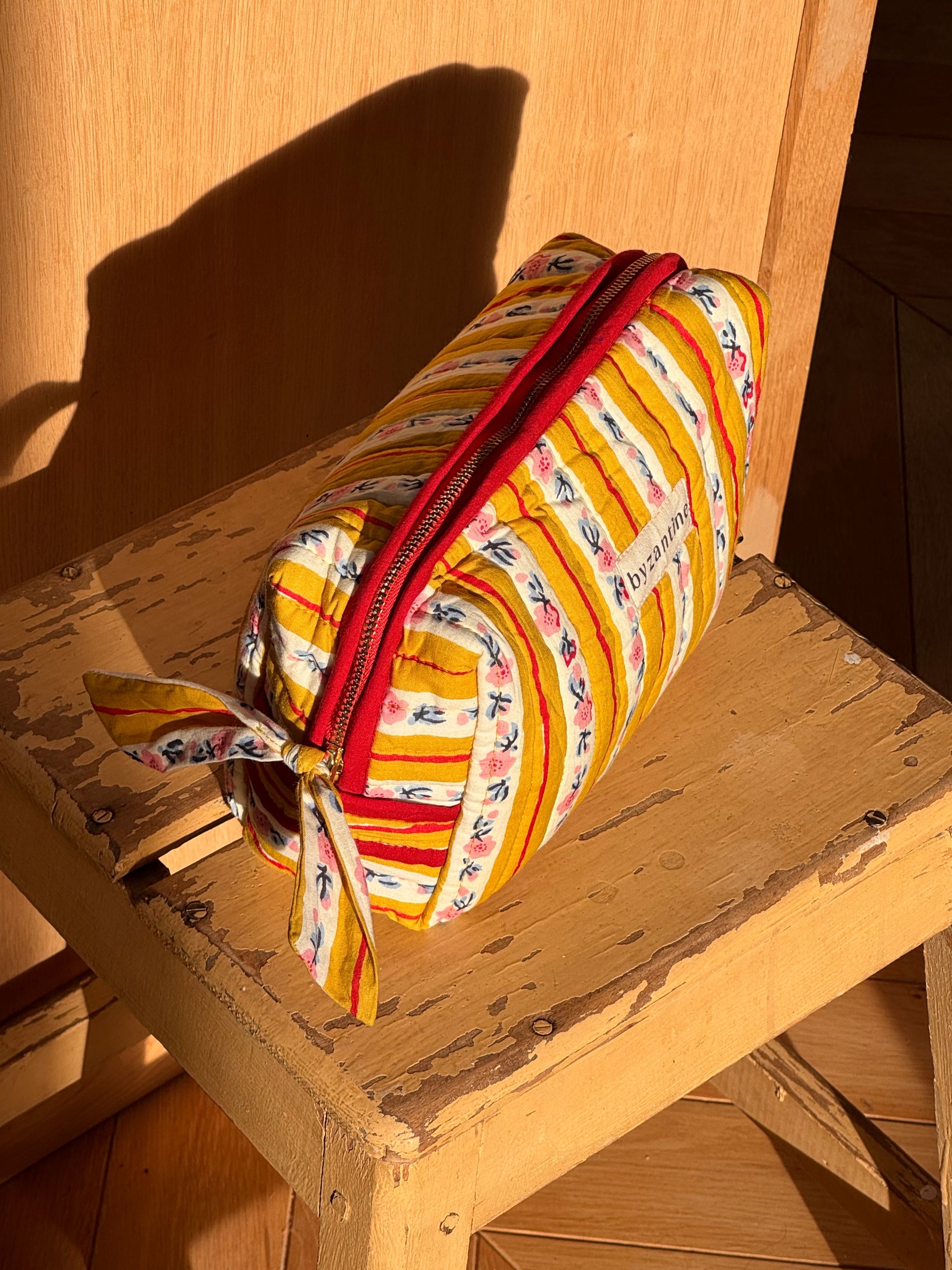 vue de haut de la trousse de toilette en coton matelassé imprimé FLORA jaune passion