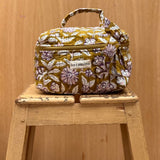 vanity en coton matelassé imprimé en block print d'un motif floral violet, écru et rose pâle sur un fond vert olive
